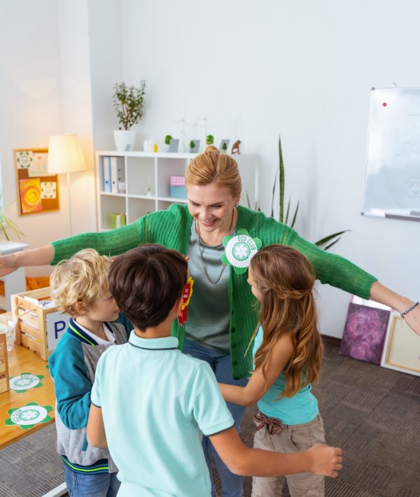 hugging-pupils-happy-loving-blonde-haired-teacher-hugging-her-diligent-pupils-after-ecology-lesson Hugging pupils. Happy loving blonde-haired teacher hugging her diligent pupils after ecology lesson