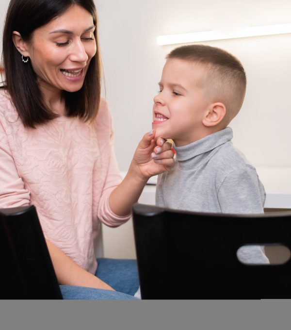 A woman speech therapist deals with the child and teaches him the correct pronunciation and competent speech. A beautiful woman speech therapist deals with the boy and teaches him the correct pronunciation and competent speech.